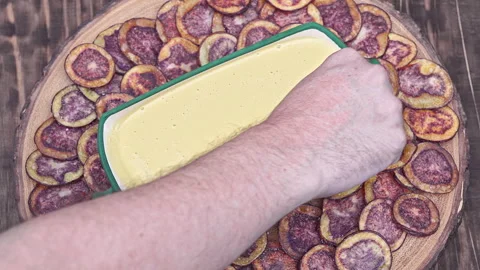 Hand dipping Peruvian purple potato chips served with Huancaina chili sauce Stock Footage 339078299