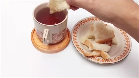 Hand dipping piece of white bread into hot black coffee cup view Stock Footage 344782757