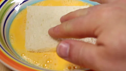 Hand Dipping White Bread in Beaten Eggs for Cooking or French Toast Preparat Stock Footage 288704054