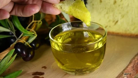 A hand dips bread into a cold pressed olive oil Stock Footage 140215472