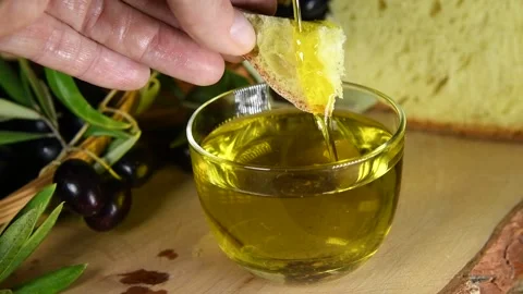 A hand dips bread into a cold pressed olive oil Video stock 140215606