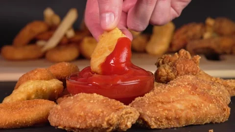 Hand dips chicken nugget into tomatoes sauce. Footage for advertise fast food, Stock Footage 272563767