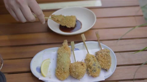 Hand dips fried panko crusted appetizer in sauce Stock Footage 226271544