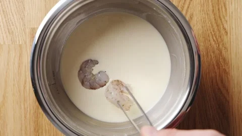 Hand dips shrimp into batter, making party finger food. Stock Footage 341429501