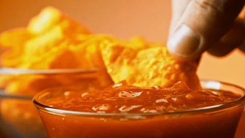Hand dips tortilla chip into salsa sauce slow motion close-up Stock Footage 122079036