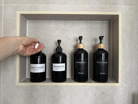 Hand dispensing conditioner from a refillable pump bottle Stock Photos