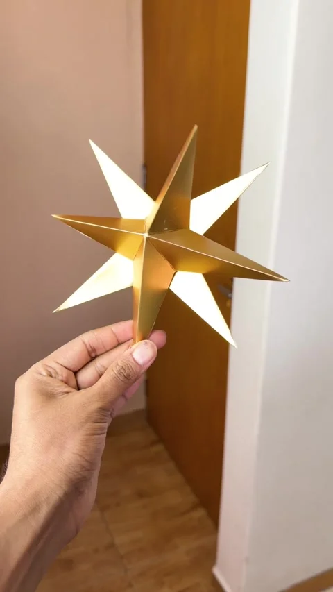 Hand Displaying Metallic Gold 3D Christmas Star Ornament Stock Footage 341460165