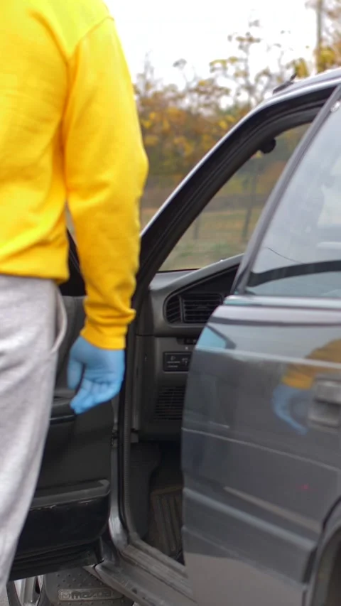 A hand in disposable gloves opens the car door and closes the door. pandemic Stock Footage 317245219