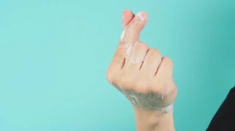 Hand is do a mini heart hand sign and have foam soap bubbles on a green mint  Foto stock
