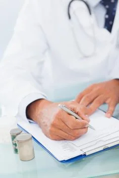 Hand of a doctor writing on a prescription pad Stock Photos