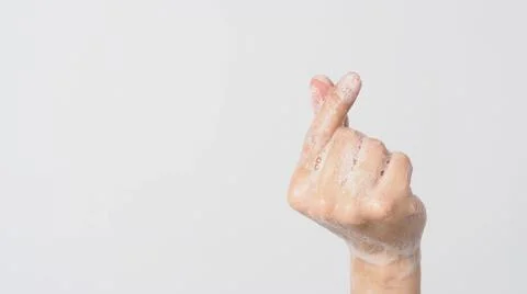 Hand doing mini heart or small heart hand sign and have foam soap bubbles on  Stock Photos