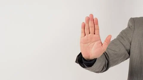 The hand is doing no or stop a hand sign in a grey suit on white background. Stock Photos