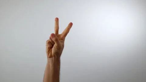 Hand doing the peace sign on a white background Video stock 137364568
