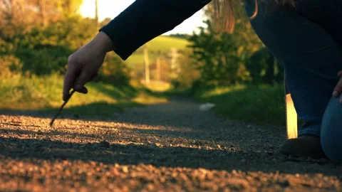 Hand doodling with stick on dusty path Stock Footage 334107853