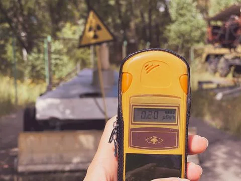 In the hand is a dosimeter that measures the level of radiation against the b Stock Photos