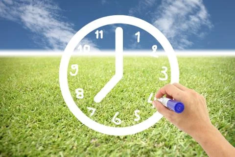 Hand is drawing a clock on lawns and blue sky. Stock Illustration