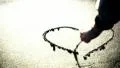 A hand drawing a heart on the sand HD Footage