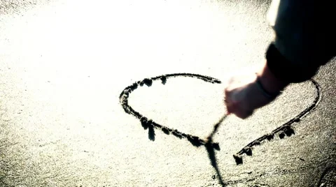 A hand drawing a heart on the sand Stock Footage 10713784