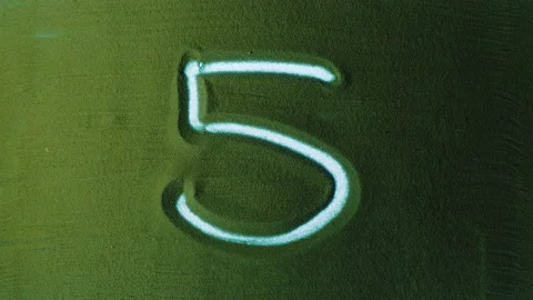 Hand drawing Number Five 5 Symbol in the Green Sand. Stock Footage 209934360