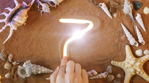 Hand drawing Number Seven 7 symbol in the sand. Beach background. Top view Stock Footage 61586897