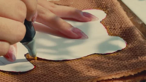A Hand Drawing the Outline of a Bear Pattern on Fabric at Build-A-Bear Workshop Stock Footage 296278384