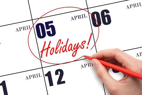 Hand drawing a red circle and writing the text Holidays on the calendar date  Stock Photos
