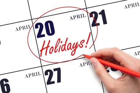 Hand drawing a red circle and writing the text Holidays on the calendar date  Stock Photos