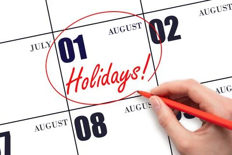 Hand drawing a red circle and writing the text Holidays on the calendar date  Stock Photos