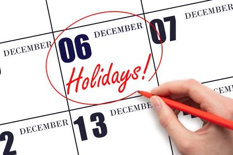 Hand drawing a red circle and writing the text Holidays on the calendar date  Stock Photos