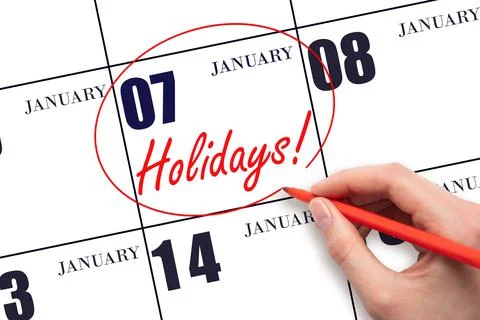 Hand drawing a red circle and writing the text Holidays on the calendar date  Stock Photos