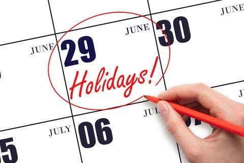 Hand drawing a red circle and writing the text Holidays on the calendar date  Stock Photos