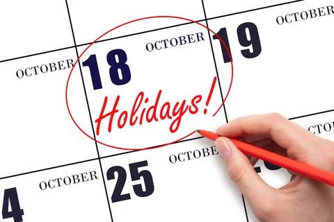 Hand drawing a red circle and writing the text Holidays on the calendar date  Stock Photos