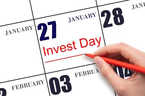Hand drawing red line and writing the text Invest Day on calendar date Januar Stock Photos
