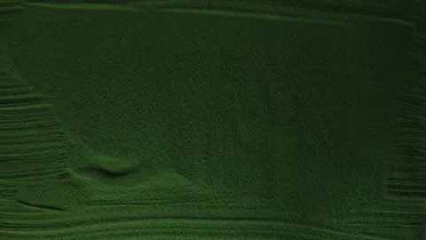 Hand drawing the Stop in the Green Sand with red backlight and then erases it. Stock Footage 209986390