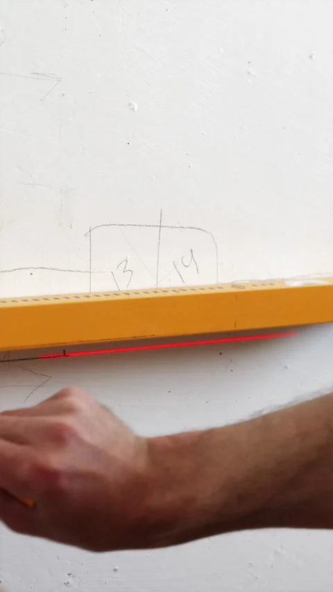 Hand drawing straight line on wall using spirit level vertical Stock Footage 339298277