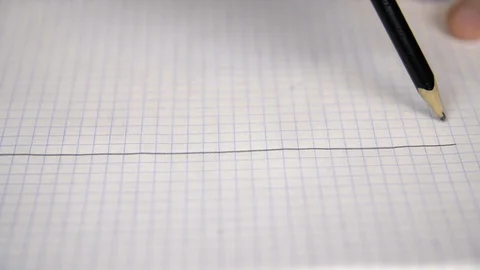 Hand drawing straight parallel lines with pencil on checkered paper in notebook Stock Footage 89322959