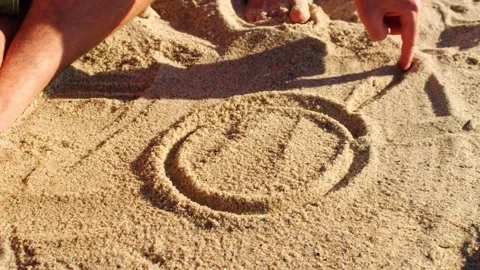 Hand Drawing Sun Symbol in Beach Sand Close Up Video stock 337082569