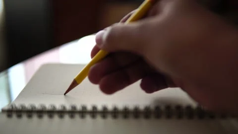 Hand drawn line with a yellow pencil on a notebook Stock Footage 147376786