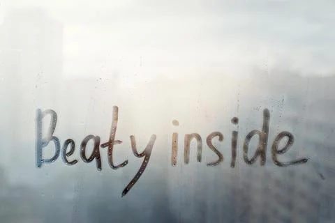 Hand drawn message Beaty inside on foggy glass on suset window Stock Photos