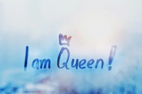Hand drawn message I am Queen on foggy glass on blue window Stock Photos