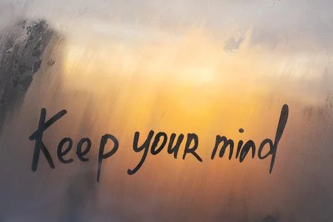 Hand drawn message Keep your mind on foggy glass on suset window Stock Photos