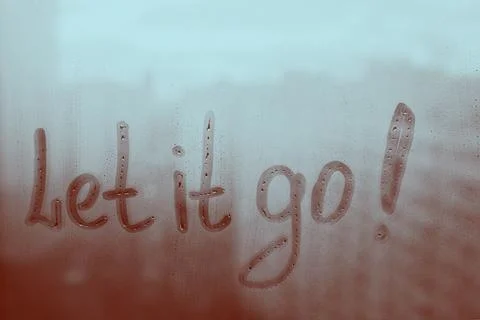 Hand drawn message Let it go on foggy glass on city window Stock Photos