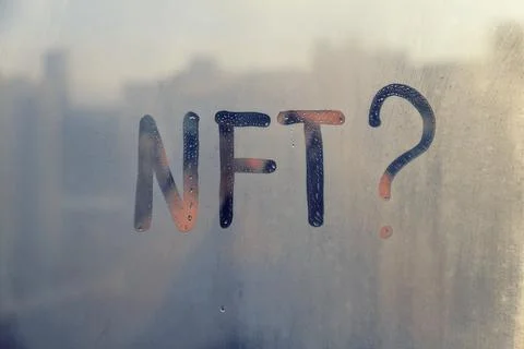 Hand drawn message NFT and question mark on foggy glass on suset window Stock Photos