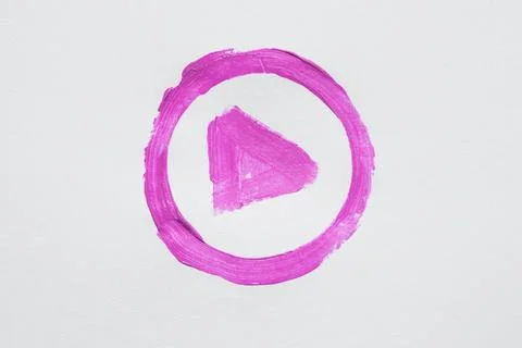 Hand drawn pink play button symbol in a circle, painted with brush on white Stock Photos