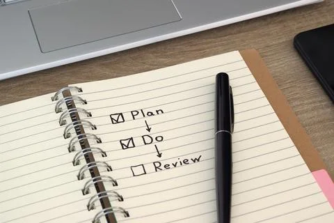 Hand-drawn Plan Do Review business process flowchart on notebook Stock Photos