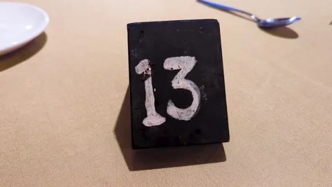 Hand drawn table number 13 thirteen in white chalk on blackboard marker on Stock Footage 344029159
