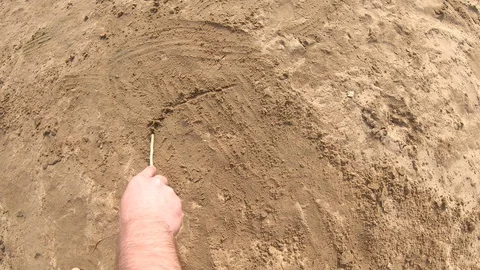 Hand draws a funny face on the sand Stock Footage 113465982