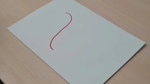 A hand draws a red line on paper followed by a green line. Stock Footage 337550093