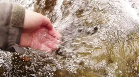 Hand Draws the Water From Flowing Mountain Stream in the First Person Stock Footage 64198697