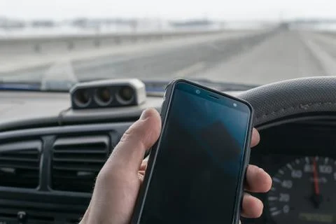In the hand of the driver of the car, a cell mobile phone Stock Photos